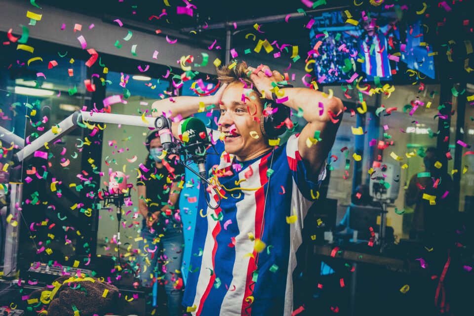 Voltage in a radio studio with his hands on his head as confetti rains down